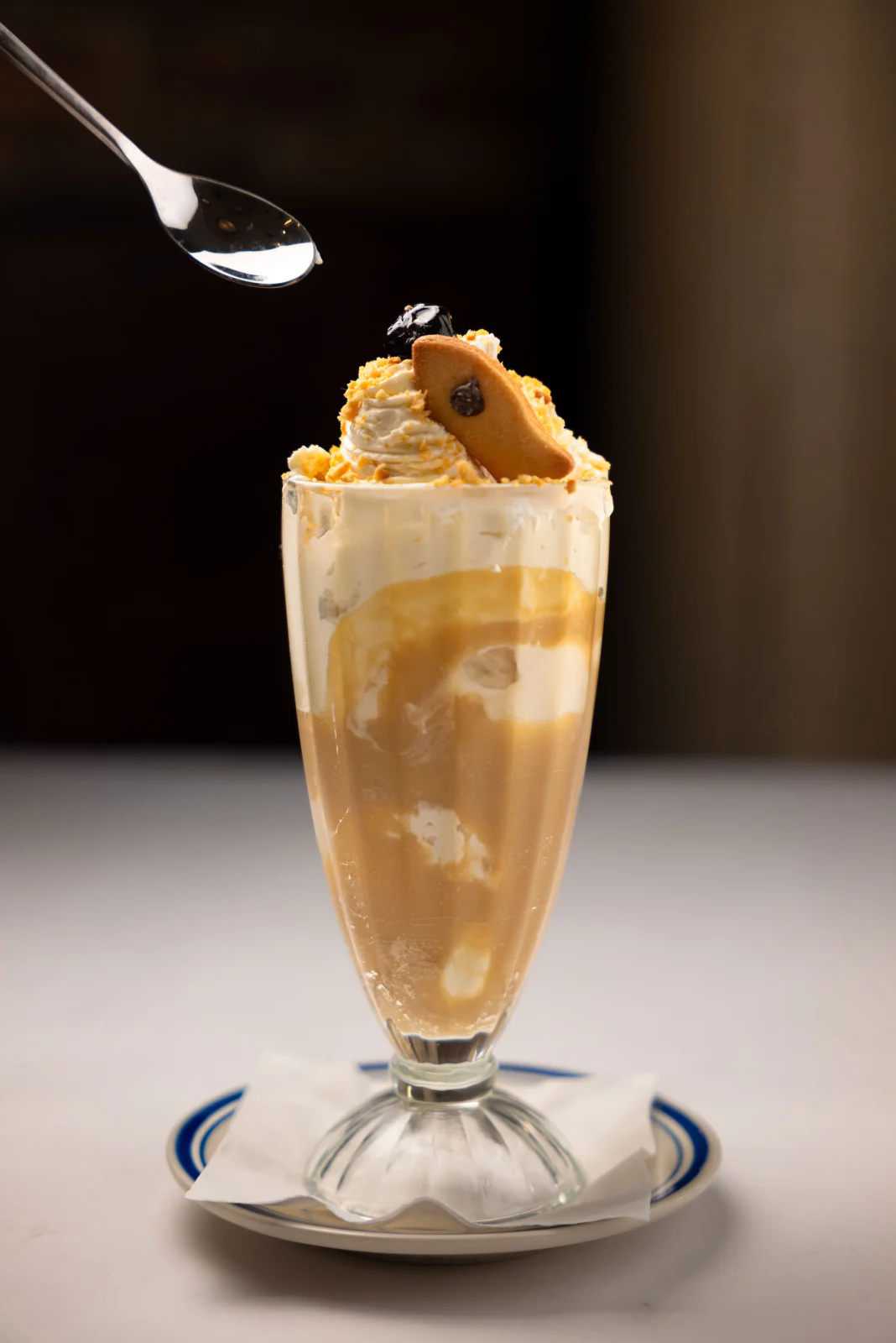 Affogato in a tall glass with a spoon of gelato