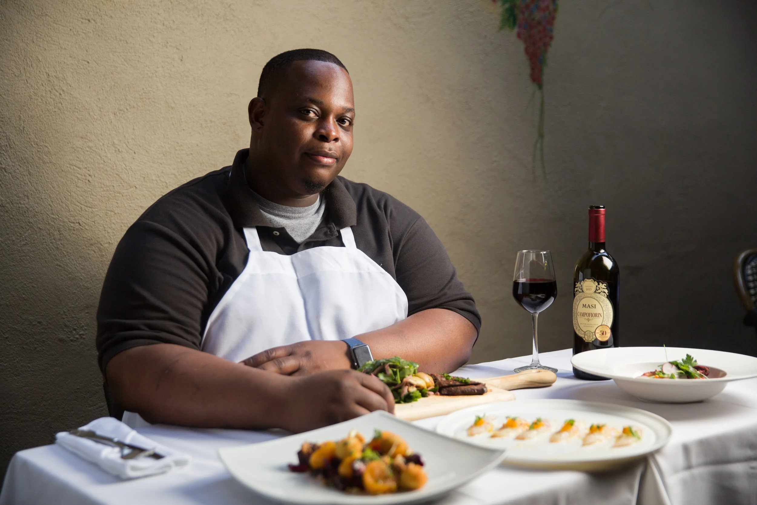 Chef seated at a set table with his dishes